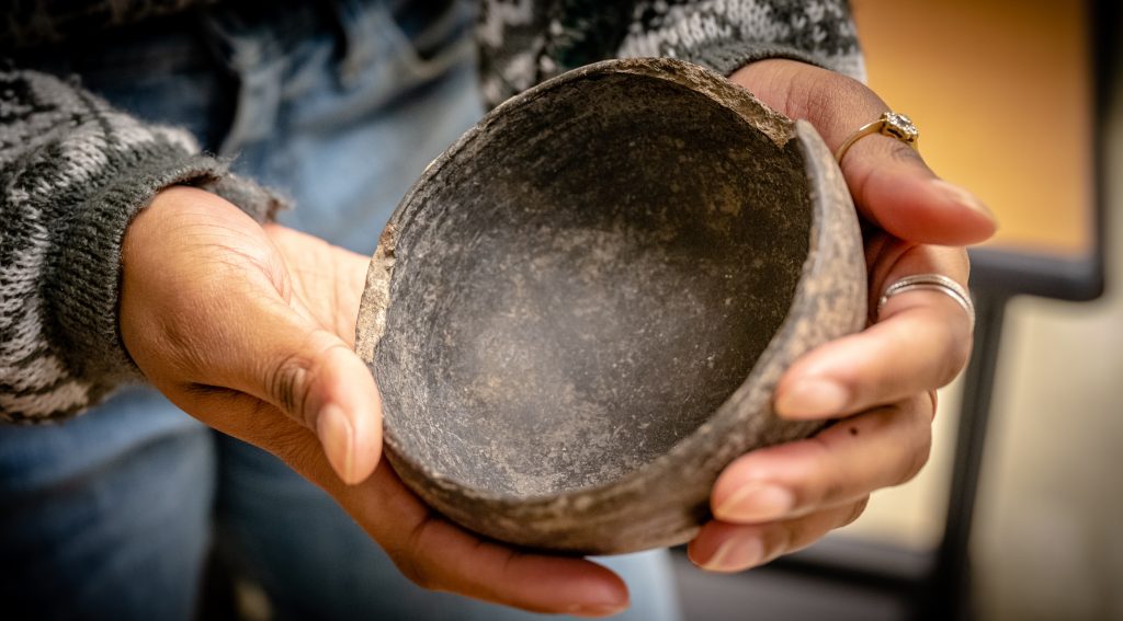 a set of hands holding a bowl artefact.