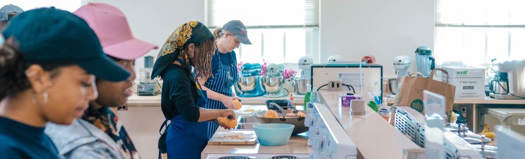 Students prepare food in a teaching classroom.