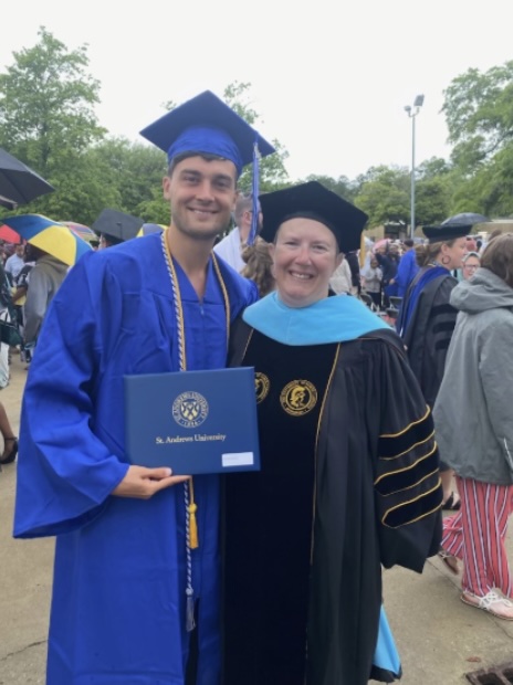 Callie Phillips wearing her UNCG doctoral gown, cape, and hood.
