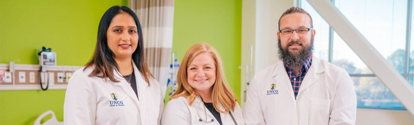 Three people wearing white nursing coats.