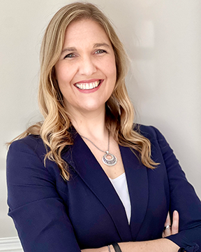 Head shot of Dr. Amanda Giordano, in a blue blazer and white shirt, in front of a tan background