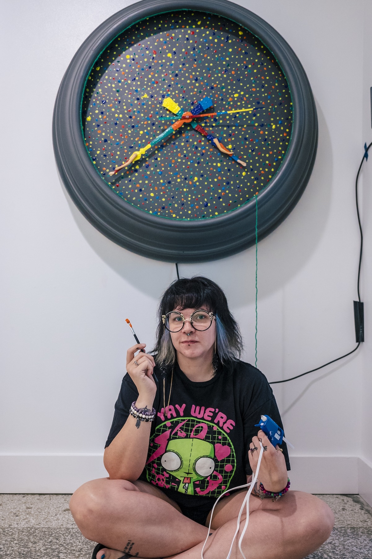 Ashe Smith sits below a clock-themed sculpture.