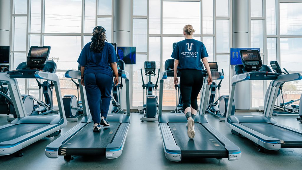 Two women walk on treadmills at UNCG Kaplan Center.