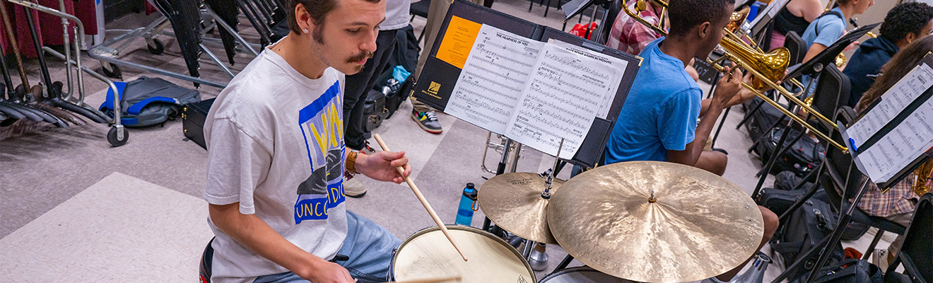 A UNCG student on the drum set.