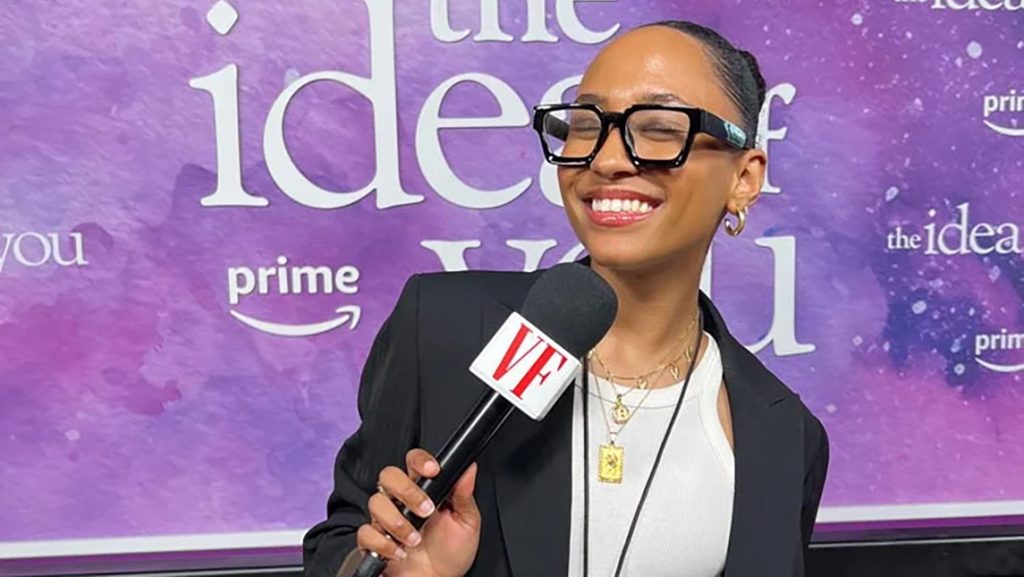Alumna smiling with microphone in her hand.