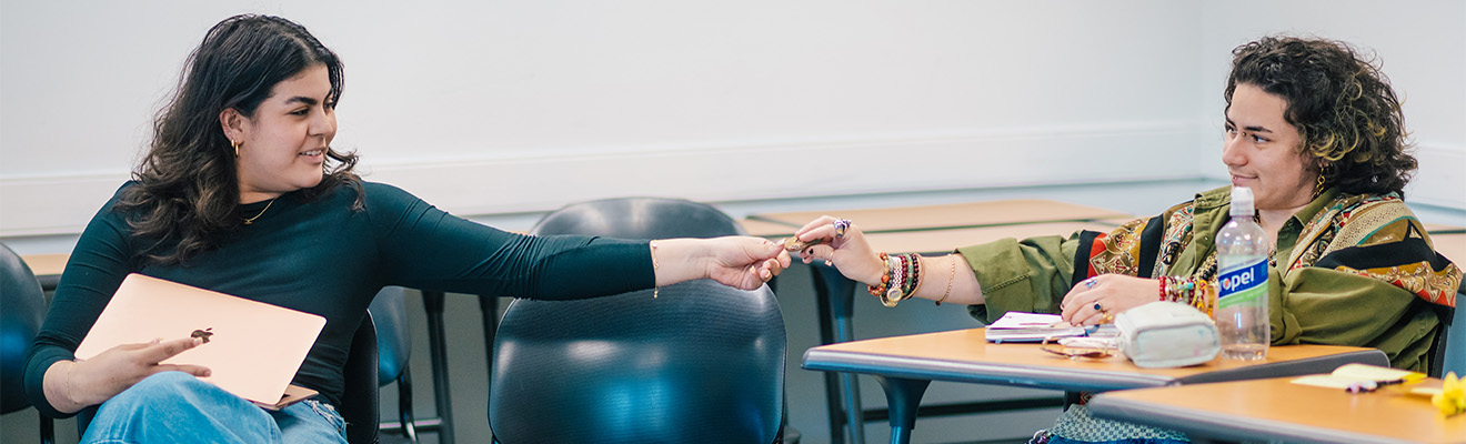 A student hands a token to another student.