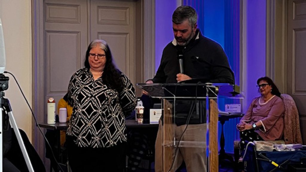A UNCG staffmember stands by a podium.