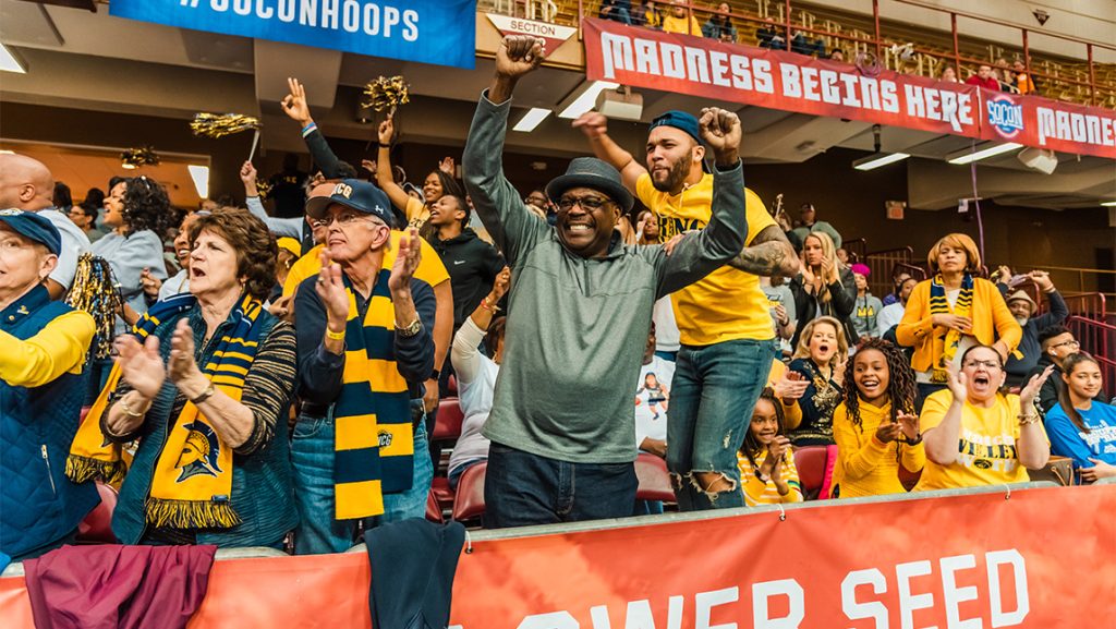 Spartan fans cheer on from the sidelines of the basketball court.