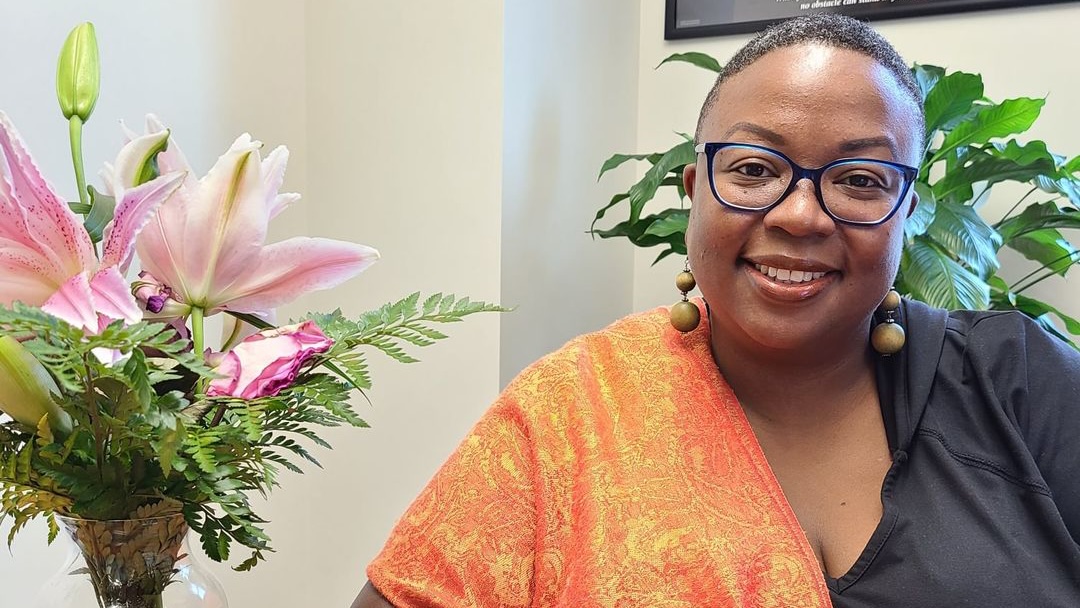 Dr. Tiffanie Lewis-Durham sits next to a vase of flowers.