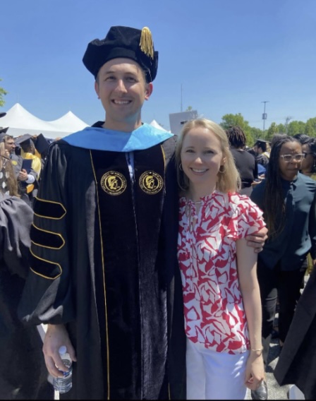 Tyler Johnston wearing his UNCG doctoral gown, cape, and hood.