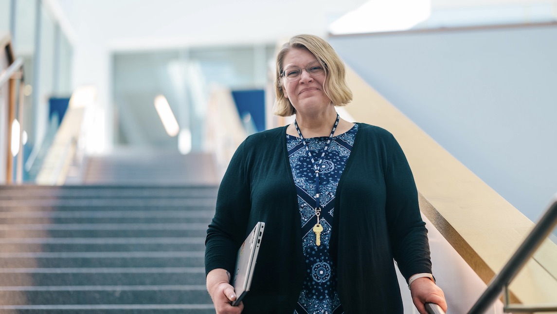 School of Nursing staff member walking down the stairs of the nursing school.
