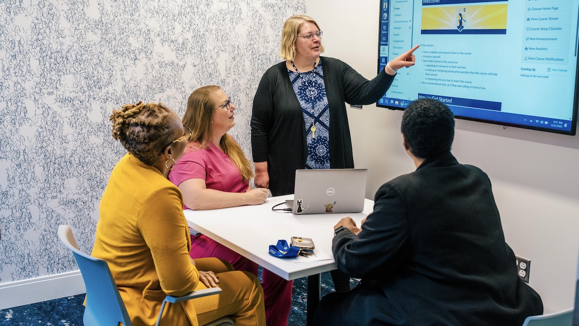 School of Nursing staff member helping students in classroom.