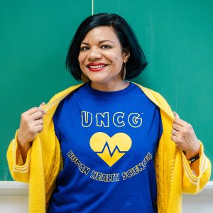 UNCG Dr. Jeannette Wade shows off her Health Human Sciences t-shirt.