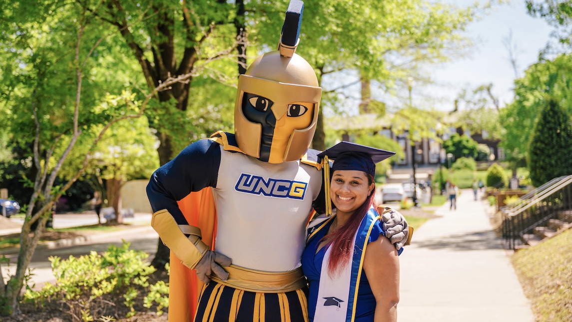 UNCG School of Nursing graduate Jyesha McKinney poses with school mascot.