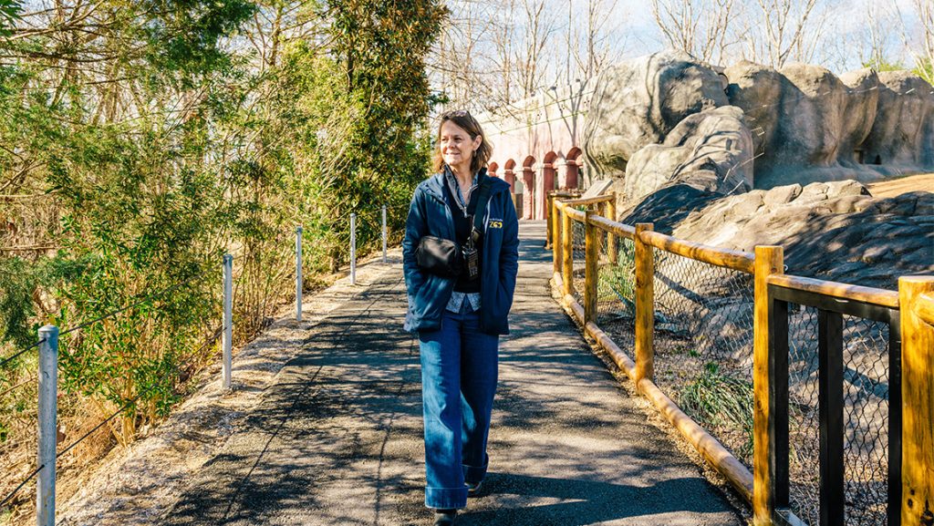 Crista McGee walks in front of the zoo's baboon exhibit.
