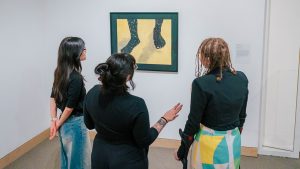 UNCG students look at museum artwork.