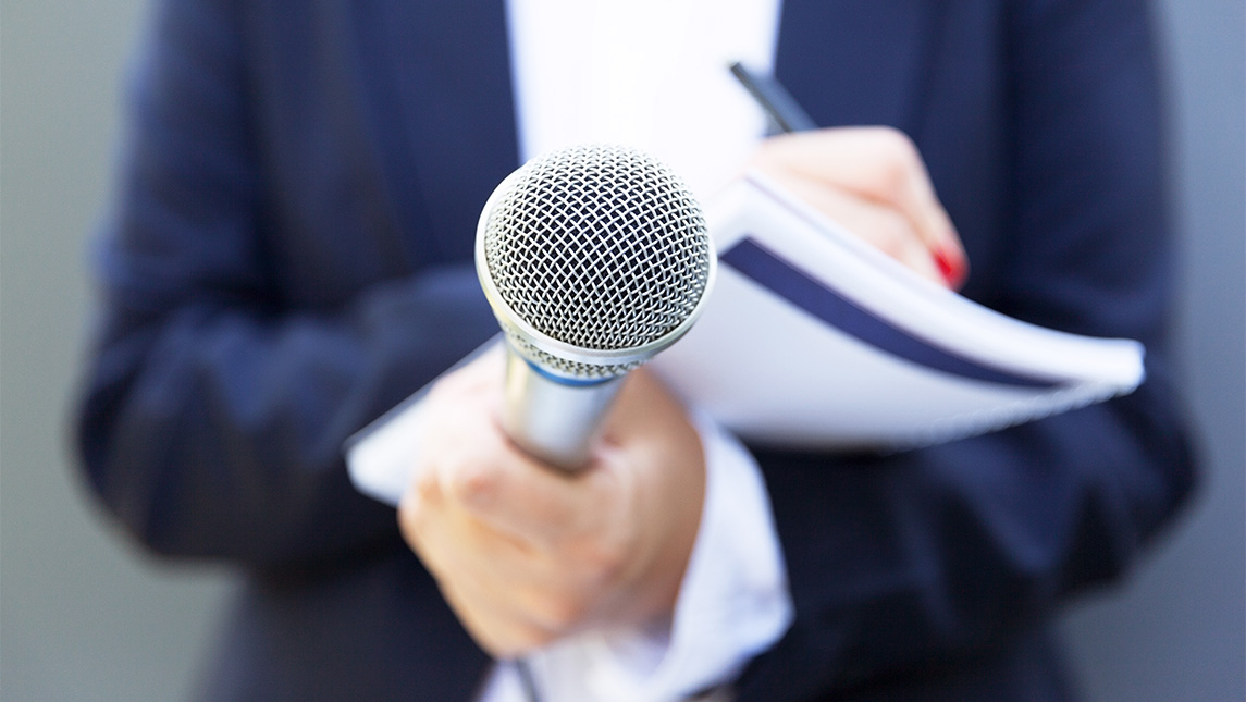 Close up on a microphone being pointed at someone.