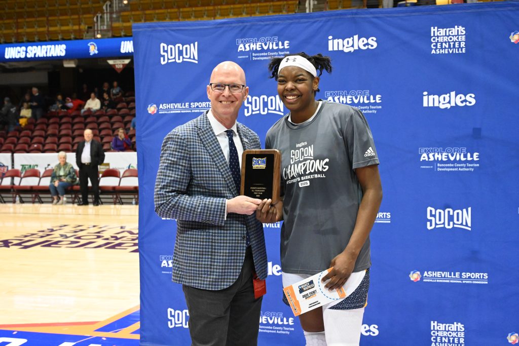 UNCG basketball player Khalis Cain receiving the MVP trophy.