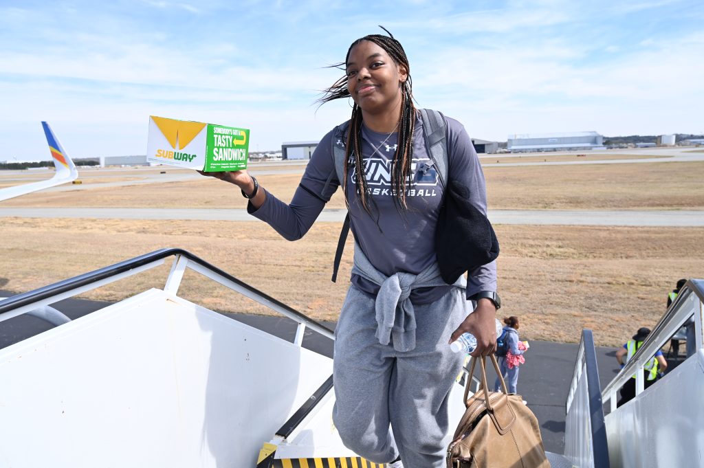 UNCG basketball player Khalis Cain boards a plane.