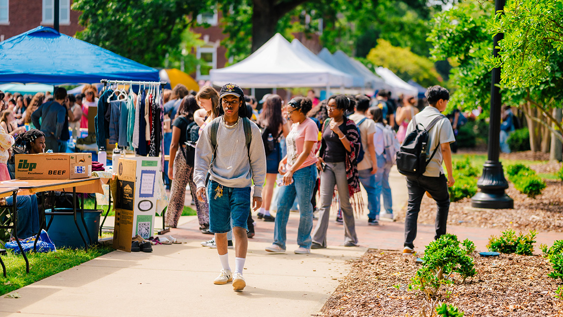 Student walking with group of students behind them.