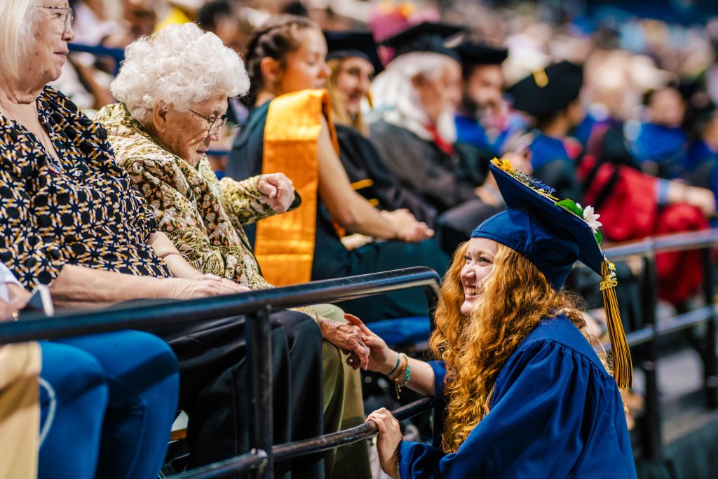 UNCG grad Truly Morgan shakes her grandmother's hand.