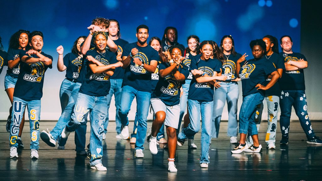 Students dressed in SOAR t-shirts dance on stage.