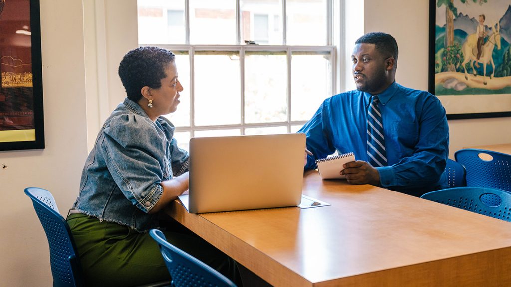UNCG grad Zion Turner talks with coordinator Alicia Streeter.