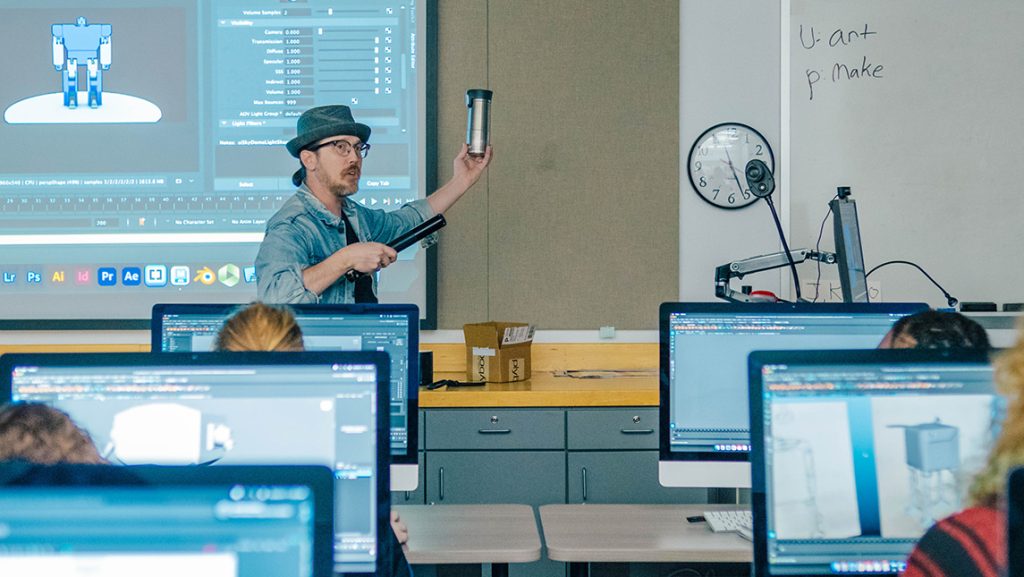 Dan Hale, UNCG Assistant Professor of Animation, holds up an object for a lesson about lighting.