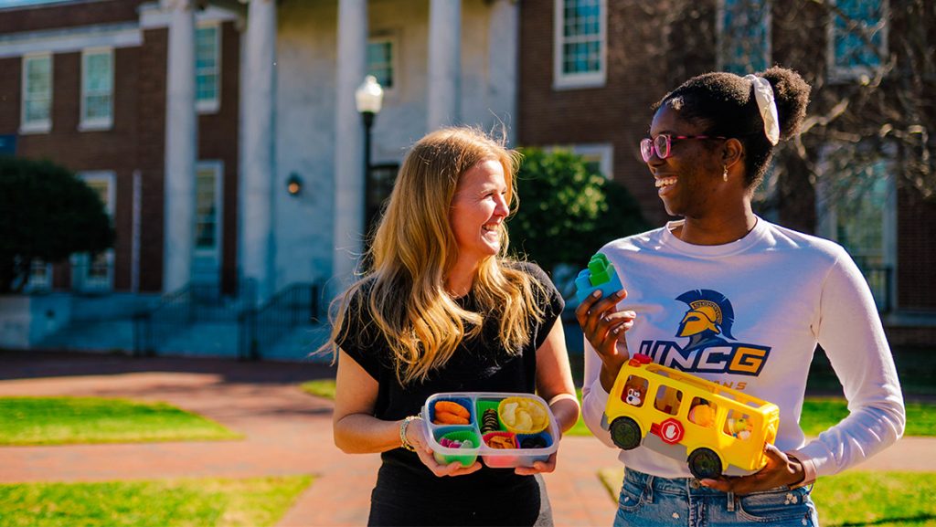 Jahleen Gourdine and Dr. Lenka Shriver hold toys they use during research at UNCG.