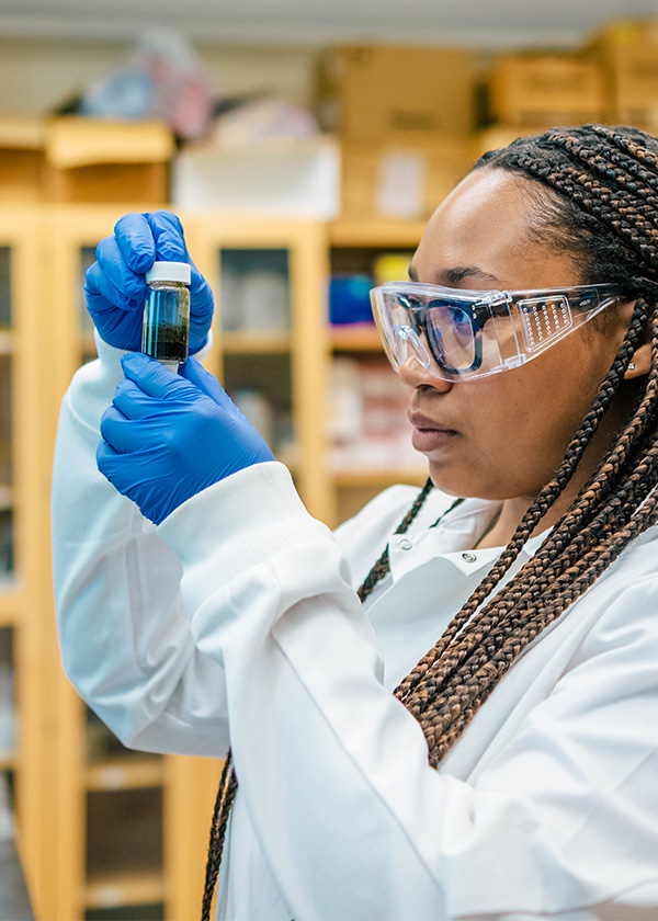 UNCG student Janae Wofford looks closely at a test tube.