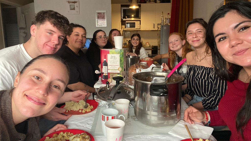 UNCG alumna Grecia Nandin eating a Thanksgiving dinner with teaching assistants in France.
