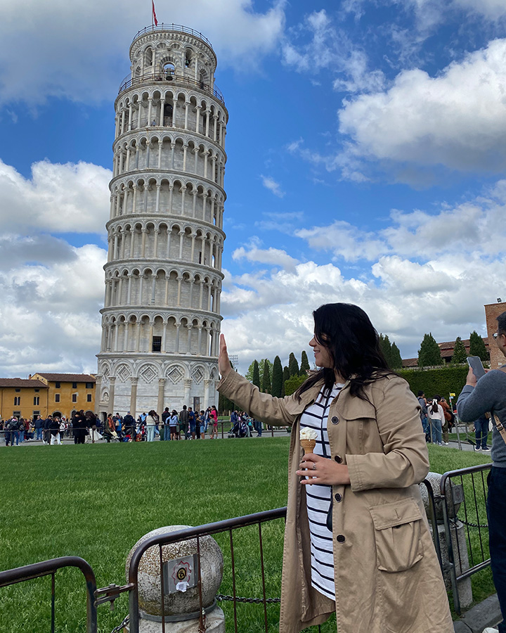 UNCG alumna Grecia Nandin pretends to hold up the Leaning Tower of Pisa.