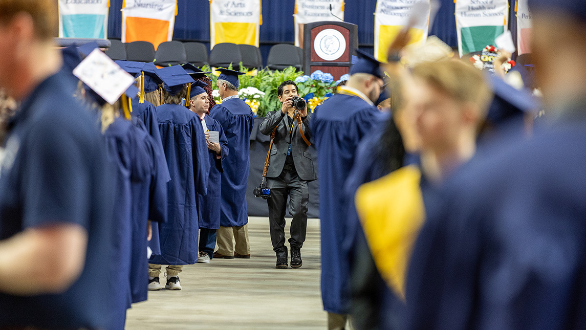 UNCG photographer Sean Norona takes pictures of graduating students.