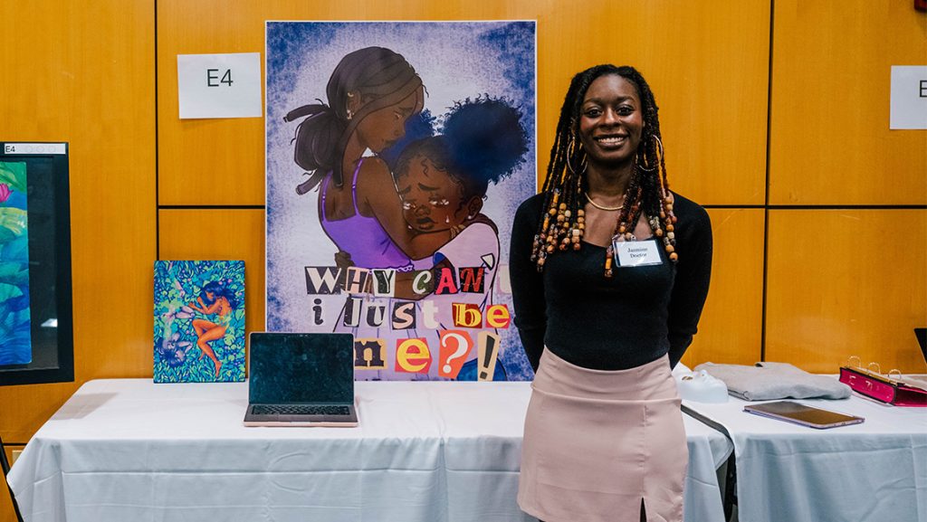 UNCG student Jasmine Doctor poses next to her artwork.