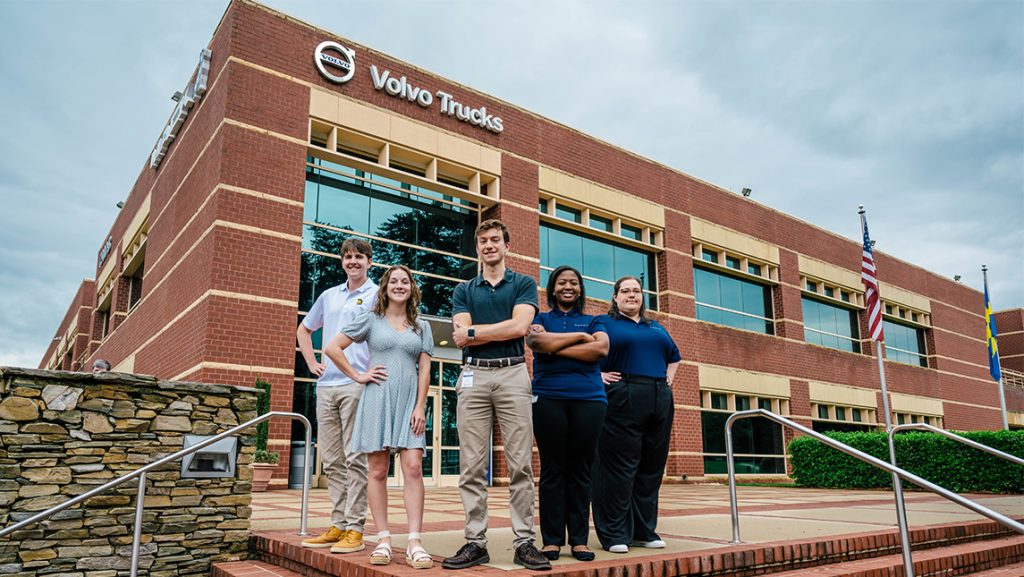 Five student interns stand in front of the Volvo building.
