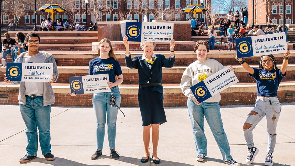 UNCG law lecturer Eloise Hassell holds up signs with students.