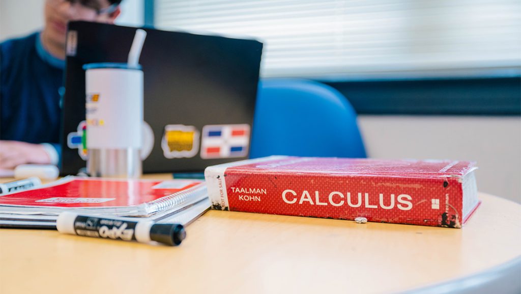 Text books on a table in the UNCG Math Help Center.
