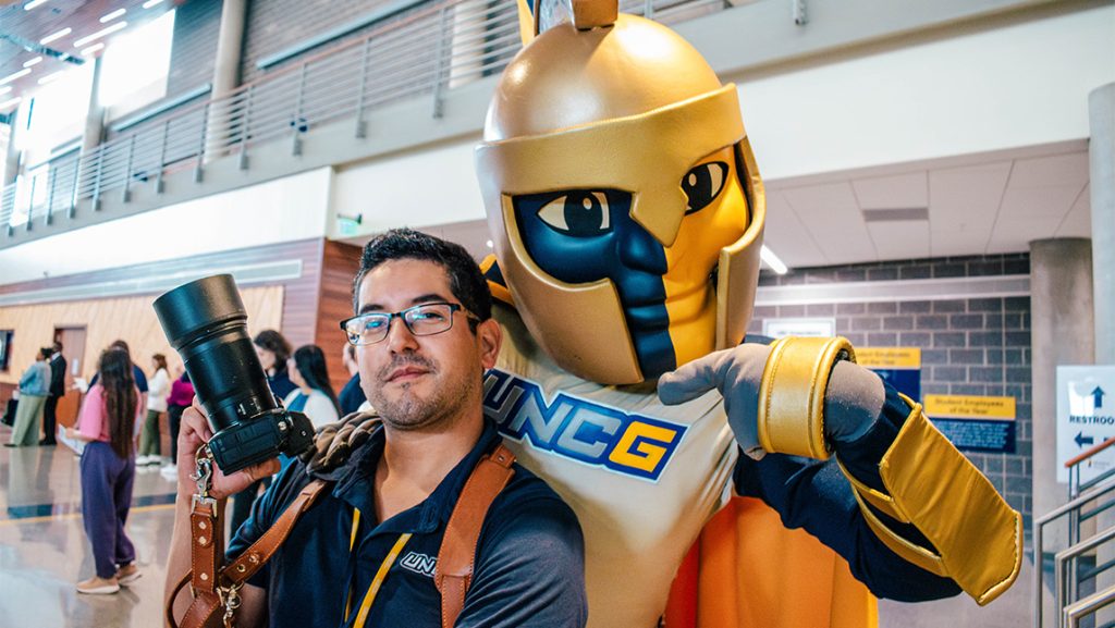 UNCG photographer Sean Norona poses with Spiro the mascot.