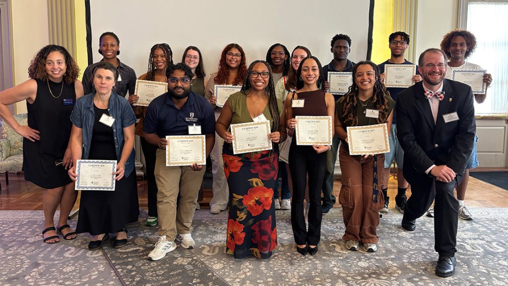 UNCG students in summer research program pose with certificates.