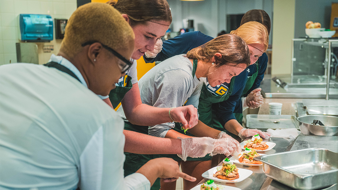 UNCG student-athletes put together a dinner in the cafeteria kitchen.