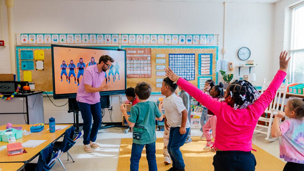 Caleb Kirk dances in his classroom with Kindergarten children.