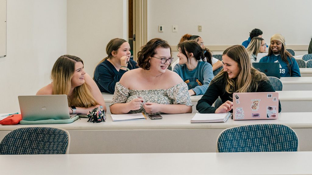 UNCG students laugh together in class.