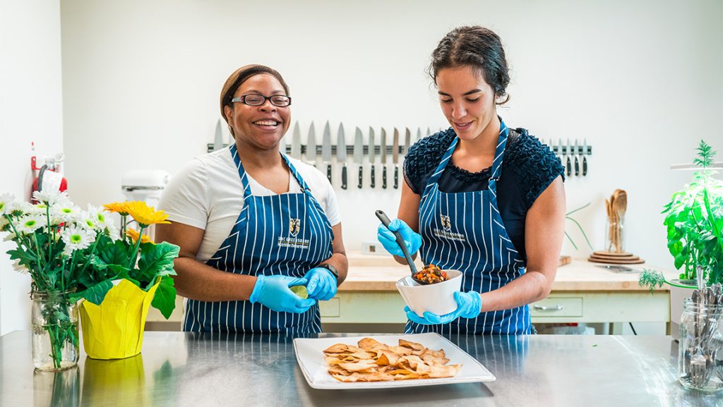 UNCG nutrition students prepare food in a kitchen.