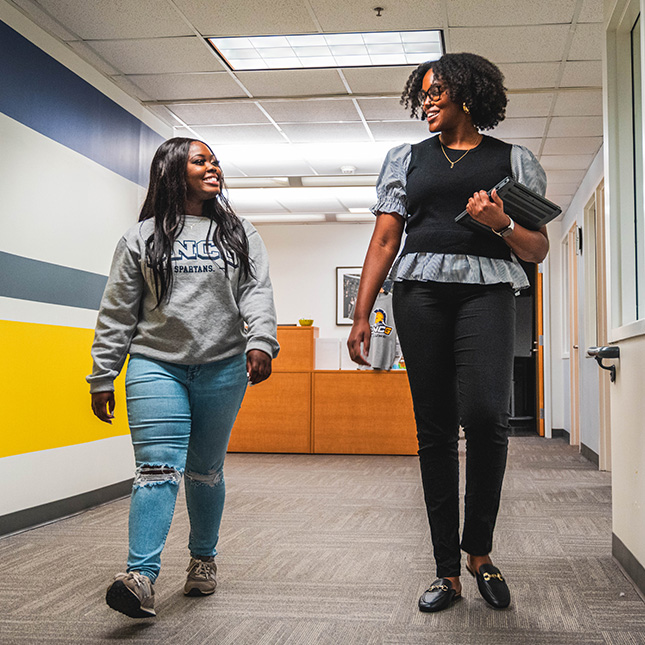 Student walks down a hall with a staff member at Career & Professional Development.