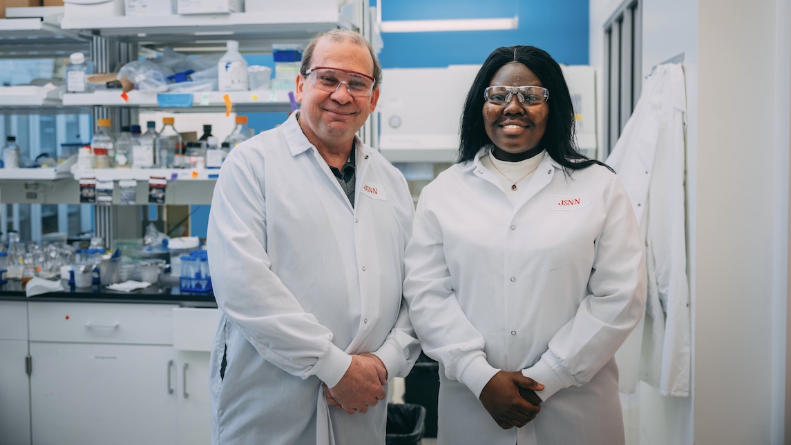 JSNN graduate Patience Kwara poses with professor in lab.