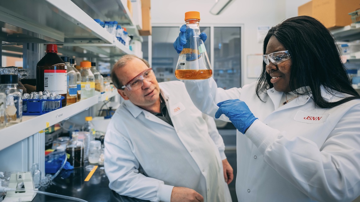 JSNN graduate Patience Kwara works with professor in lab.