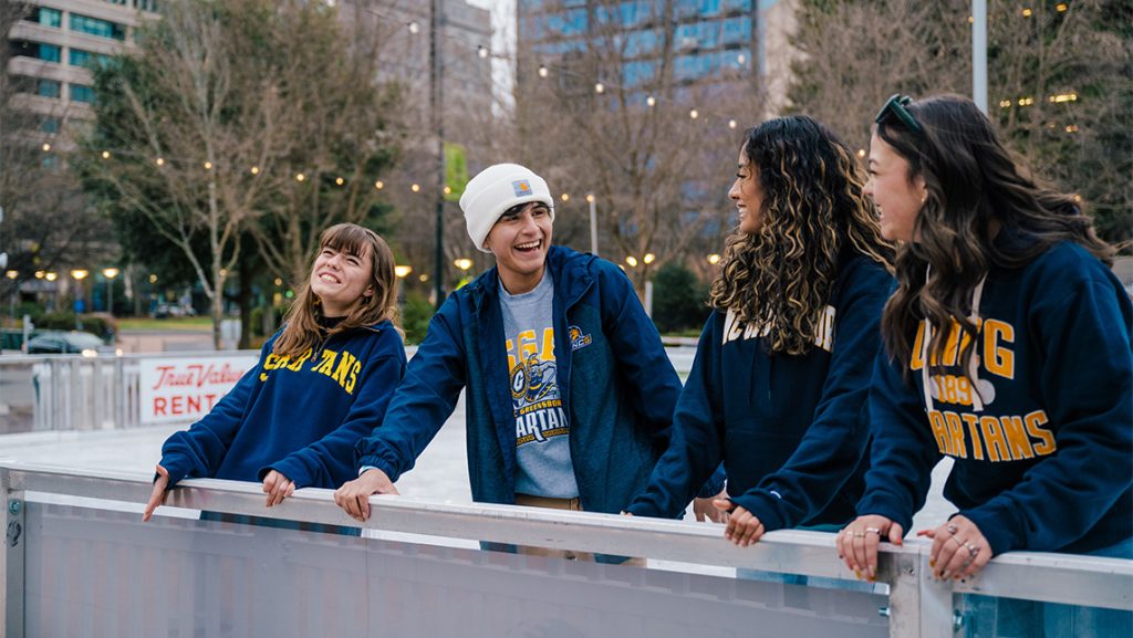 UNCG students laugh while on the ice rink.