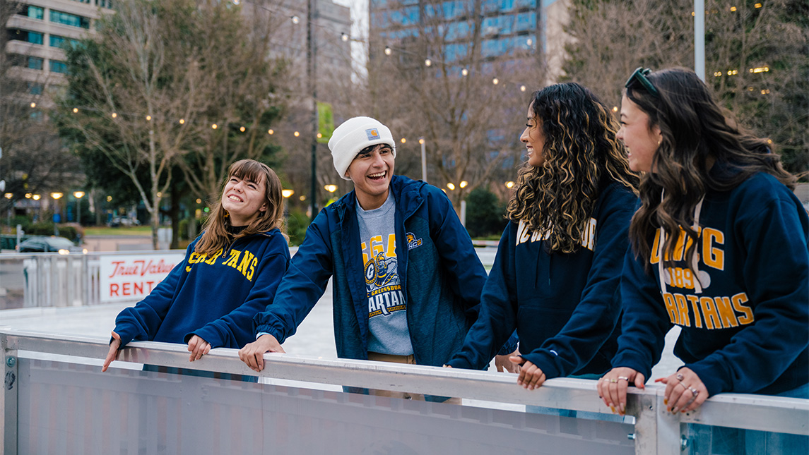 UNCG students laugh while on the ice rink.