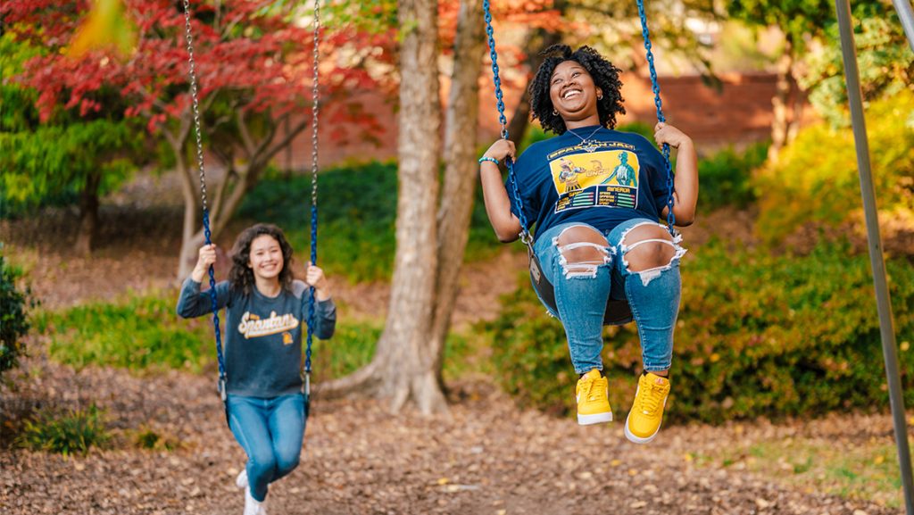 UNCG students on the swing.
