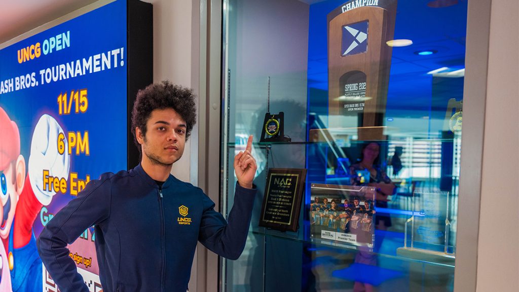 UNCG Smash player Jordan Marelli points to his trophies.